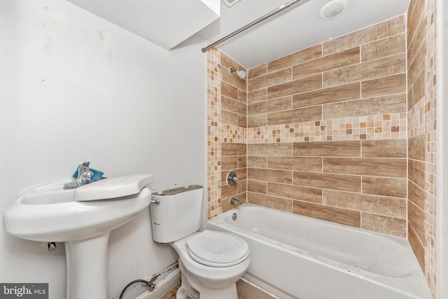 bathroom featuring toilet and tiled shower / bath