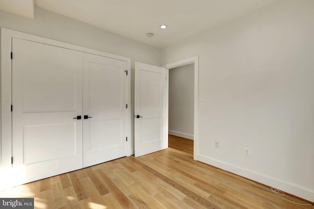 unfurnished bedroom featuring a closet and light hardwood / wood-style flooring