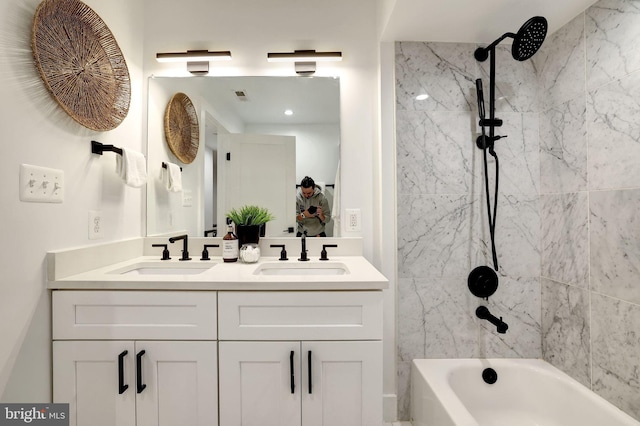 bathroom featuring tiled shower / bath and vanity