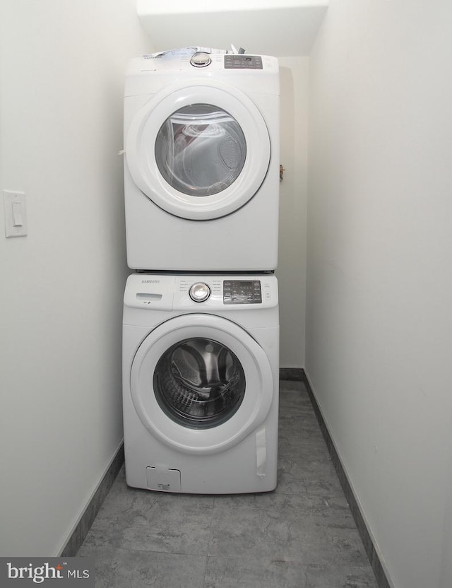 washroom with stacked washing maching and dryer