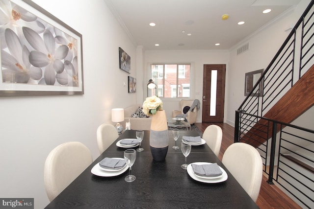 dining room featuring ornamental molding and dark hardwood / wood-style floors