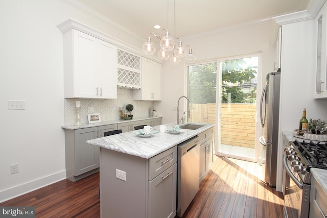 kitchen featuring stainless steel appliances, gray cabinets, a kitchen island with sink, and dark wood-type flooring