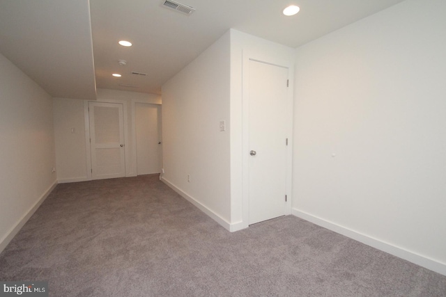 hall with light colored carpet