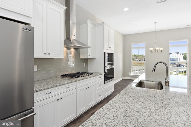 kitchen with sink, wall chimney exhaust hood, white cabinetry, stainless steel appliances, and dark hardwood / wood-style floors