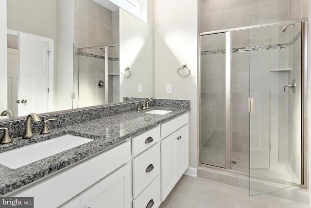 bathroom with vanity, a shower with door, and tile patterned floors