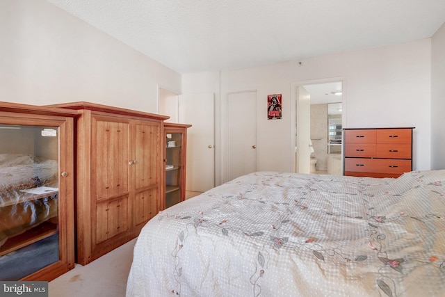 bedroom with light colored carpet and connected bathroom