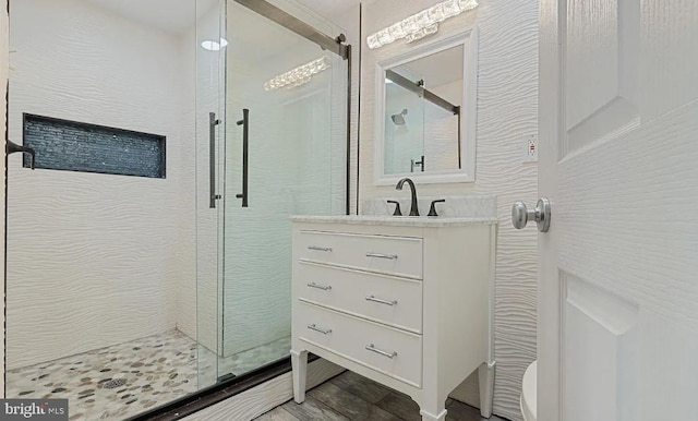 bathroom with an enclosed shower, vanity, and hardwood / wood-style flooring