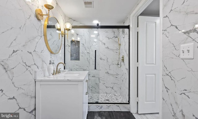 bathroom with tile walls, vanity, and a shower with door