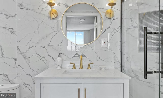 bathroom with vanity, tile walls, and toilet