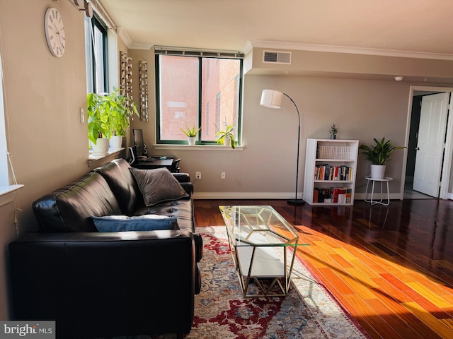 living room with hardwood / wood-style floors, crown molding, and a healthy amount of sunlight