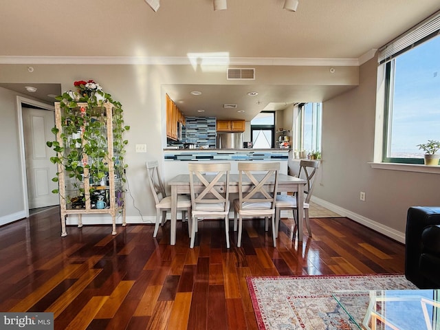 dining space featuring crown molding and dark wood-type flooring