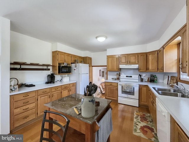 kitchen with sink, a center island, dark hardwood / wood-style floors, and white appliances