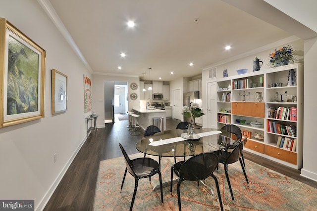 dining area featuring ornamental molding and dark hardwood / wood-style flooring