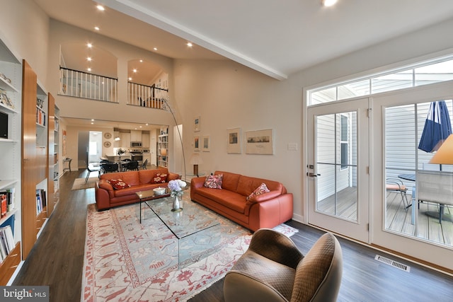 living room with wood-type flooring and high vaulted ceiling