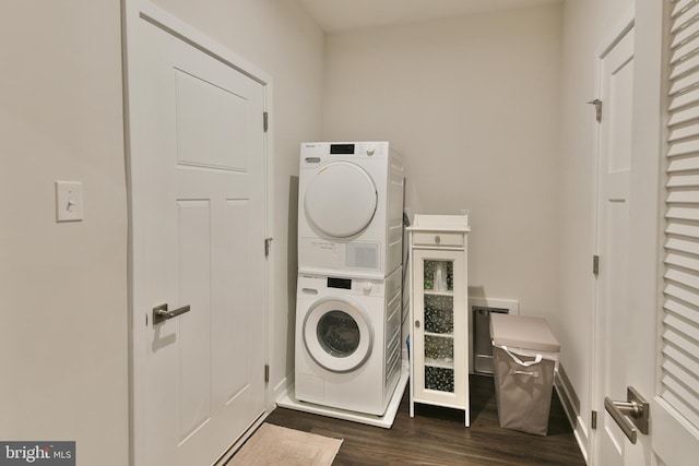 laundry room featuring stacked washer / drying machine and dark hardwood / wood-style flooring