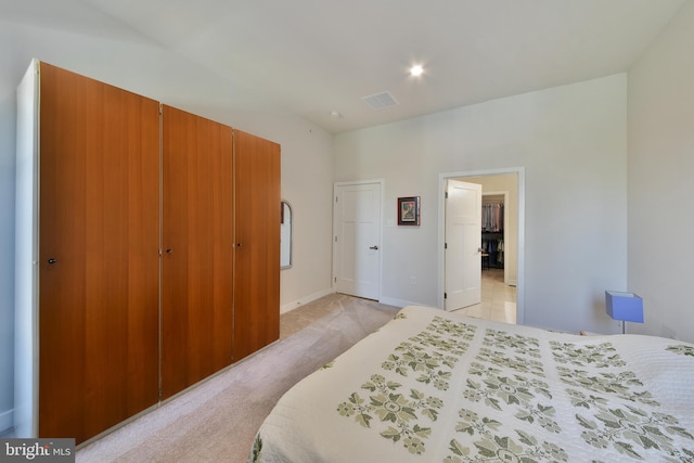 bedroom featuring light carpet and a closet