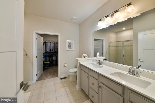 bathroom with vanity, tile patterned floors, toilet, and an enclosed shower