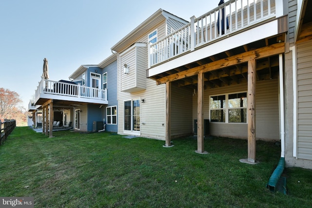 back of property with a deck and a lawn