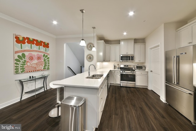 kitchen featuring white cabinets, hanging light fixtures, appliances with stainless steel finishes, dark wood-type flooring, and sink