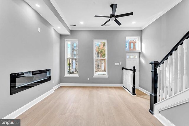 unfurnished living room with ornamental molding, light hardwood / wood-style flooring, and ceiling fan