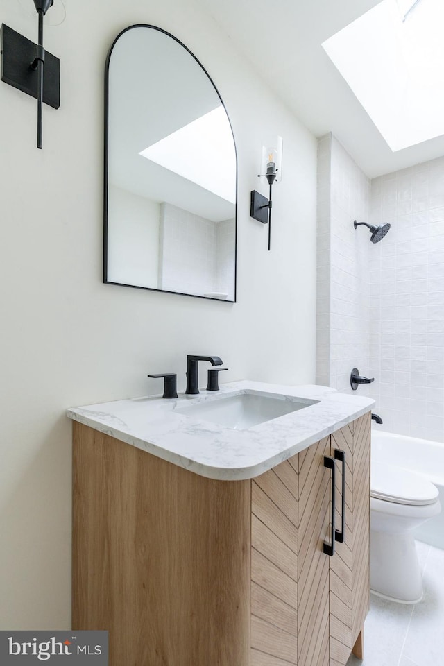 full bathroom featuring tile patterned flooring, vanity, tiled shower / bath combo, and toilet