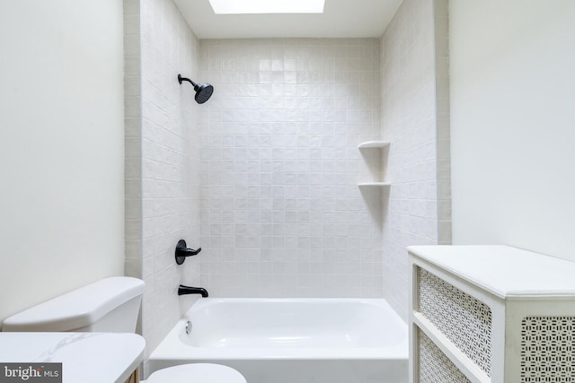 bathroom with tiled shower / bath combo and toilet