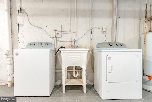 laundry area with washing machine and clothes dryer and water heater