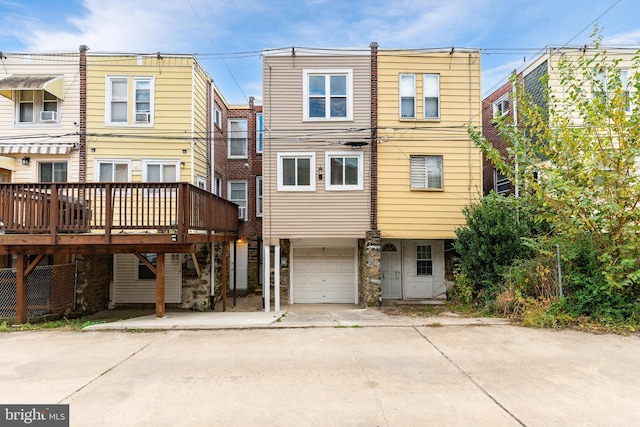 rear view of house with a deck and a garage