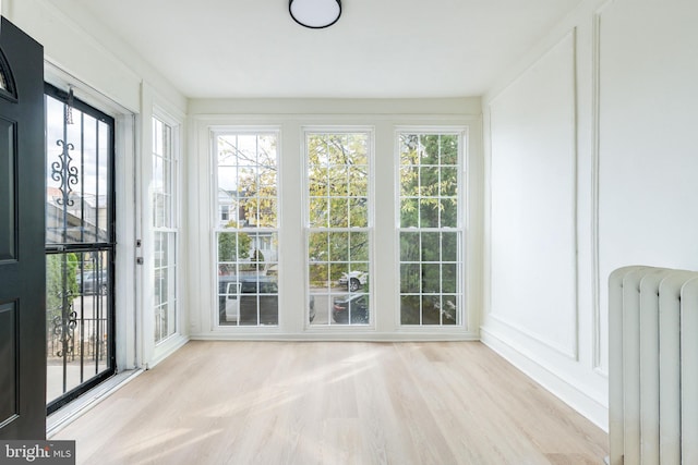 unfurnished sunroom featuring radiator and a healthy amount of sunlight