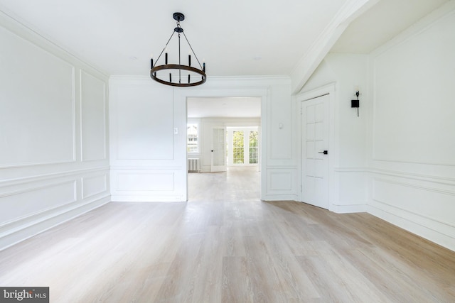 interior space featuring light hardwood / wood-style flooring, radiator, ornamental molding, and a notable chandelier