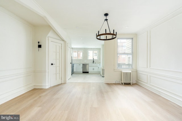 interior space featuring light hardwood / wood-style floors, radiator heating unit, and crown molding