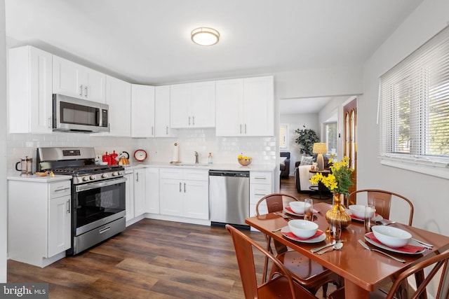 kitchen featuring stainless steel appliances, dark hardwood / wood-style flooring, decorative backsplash, and white cabinetry