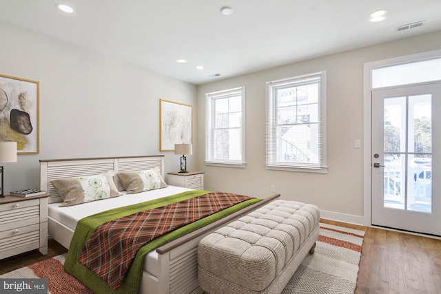 bedroom featuring baseboards, wood finished floors, visible vents, and recessed lighting