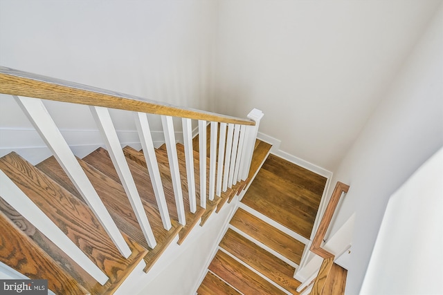 staircase with wood finished floors and baseboards