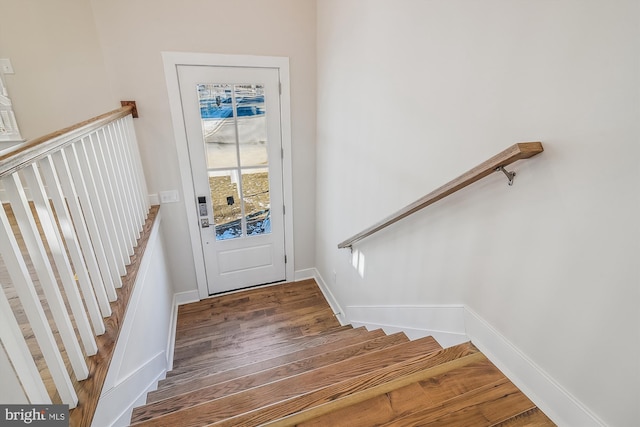 doorway to outside featuring baseboards, stairway, and wood finished floors