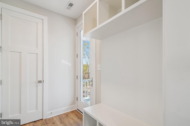 mudroom featuring baseboards, visible vents, and light wood-style floors