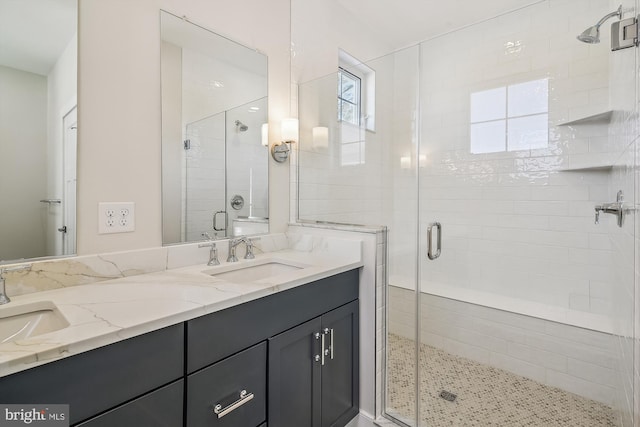 bathroom with double vanity, a stall shower, and a sink