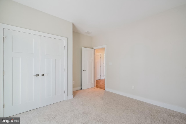 unfurnished bedroom with carpet, baseboards, and a closet