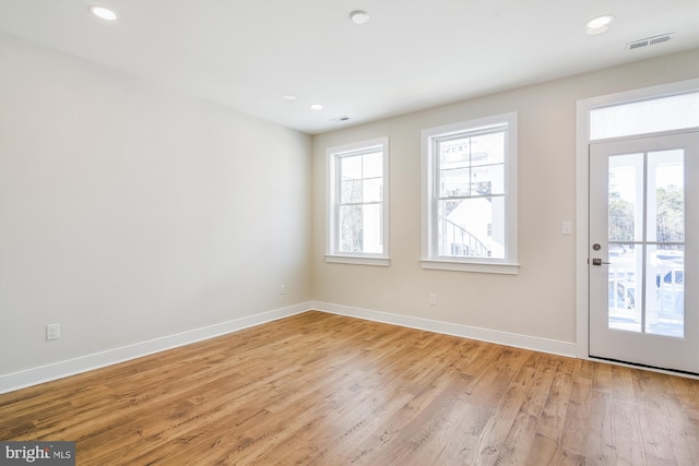 doorway with light wood-style floors, baseboards, visible vents, and recessed lighting