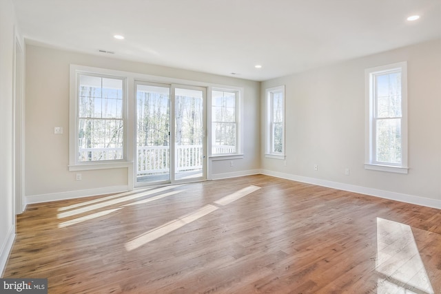 unfurnished room featuring baseboards, wood finished floors, and recessed lighting