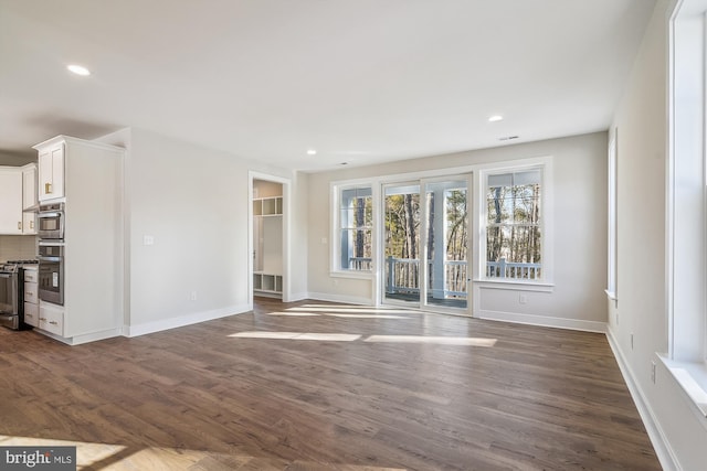 unfurnished living room featuring recessed lighting, dark wood-style flooring, and baseboards