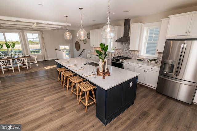 kitchen with appliances with stainless steel finishes, a kitchen breakfast bar, wall chimney exhaust hood, and dark wood-style floors