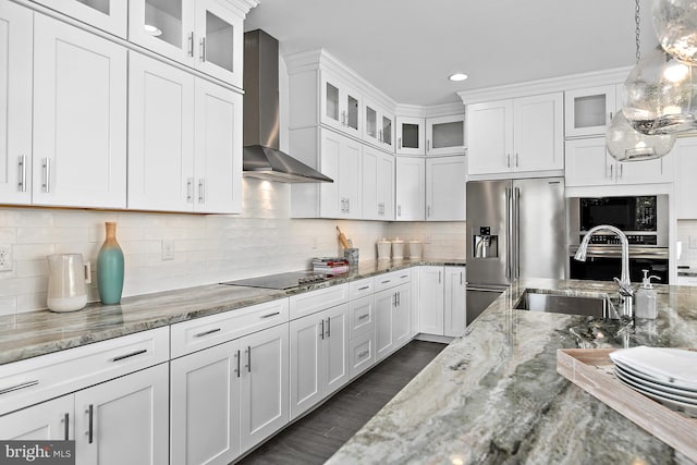 kitchen featuring pendant lighting, wall chimney exhaust hood, white cabinetry, and black appliances