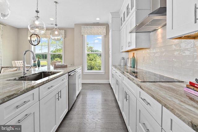 kitchen featuring light stone countertops, wall chimney exhaust hood, sink, and white cabinetry