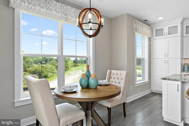 dining area with plenty of natural light, a chandelier, and dark hardwood / wood-style flooring