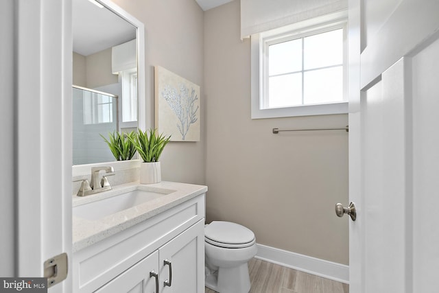 bathroom with an enclosed shower, hardwood / wood-style flooring, vanity, and toilet