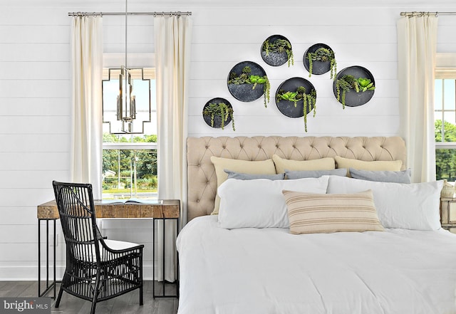 bedroom featuring wood walls and hardwood / wood-style floors