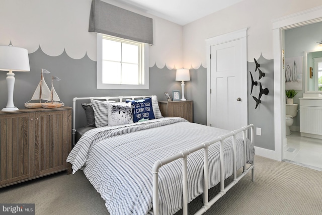 bedroom with ensuite bath and carpet