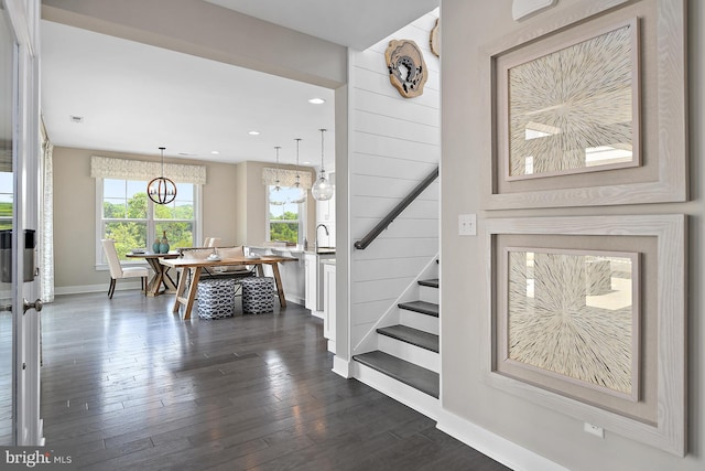 foyer with an inviting chandelier, dark hardwood / wood-style floors, and sink