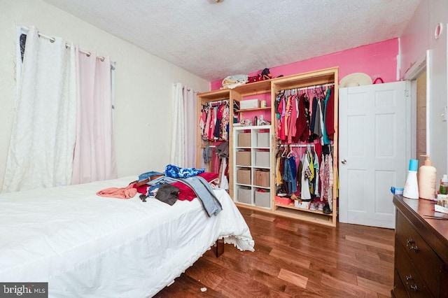 bedroom featuring wood-type flooring, a textured ceiling, and a closet